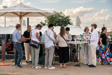 Mitarbeiterinnen der IK TH und AKT stehen am Einlass, kontrollieren die Tickets und vergeben Bändchen und Verzehrmarken aus