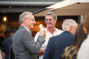 Zwei Männer unterhalten sich, ein Mann hat ein Bierglas in der Hand