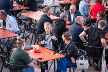 Personen sitzen an einem Tisch und unterhalten sich