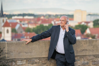 Ein Mann steht an einer Mauer und telefoniert